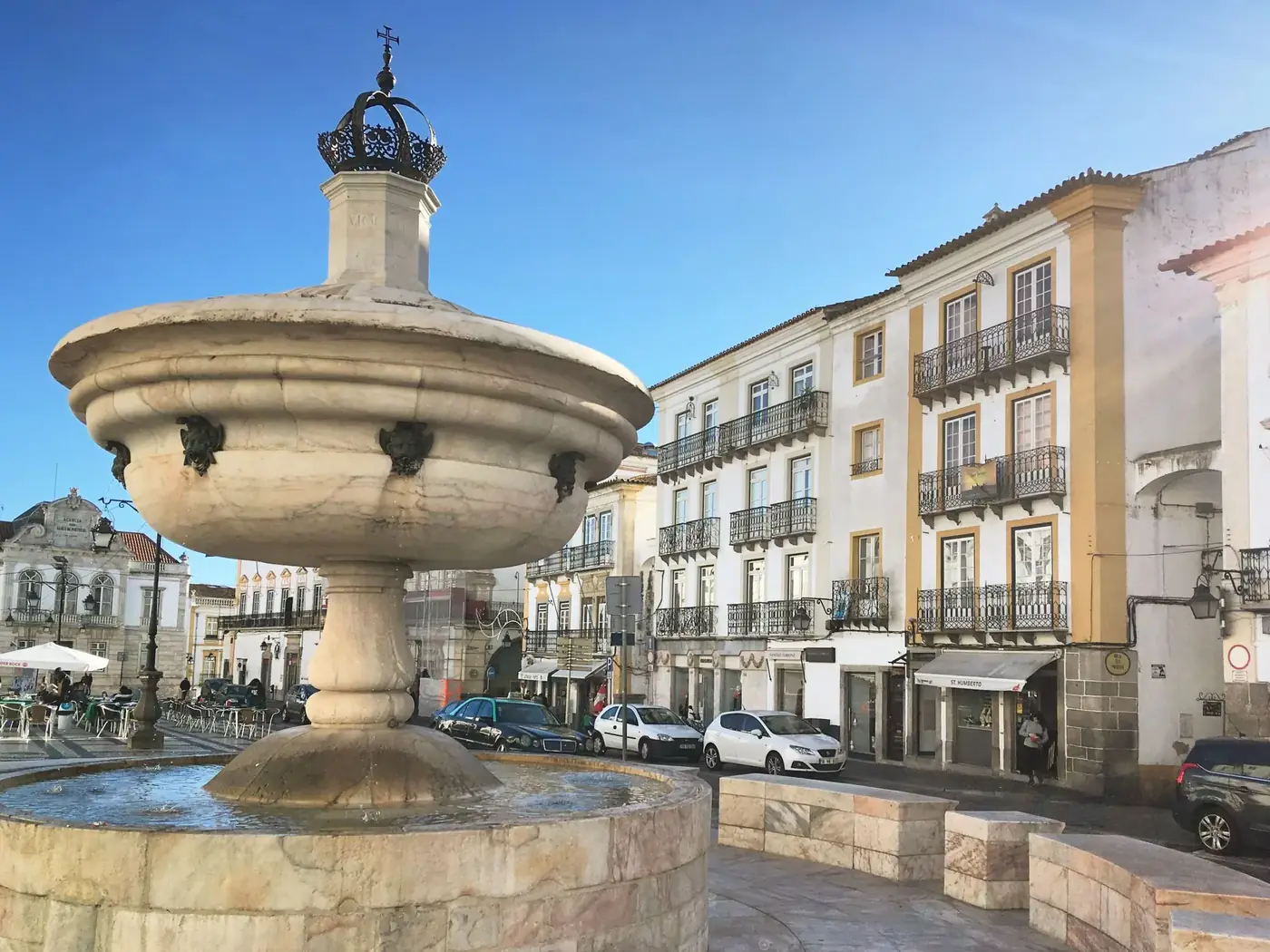 Majestic stone fountain at Praça do Giraldo in Évora, Portugal, showcasing classic architecture.