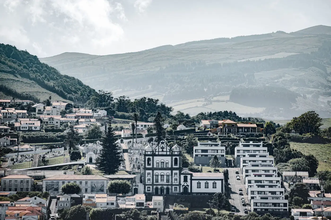 Picturesque view of Horta in the Azores, featuring traditional architecture and lush hills.