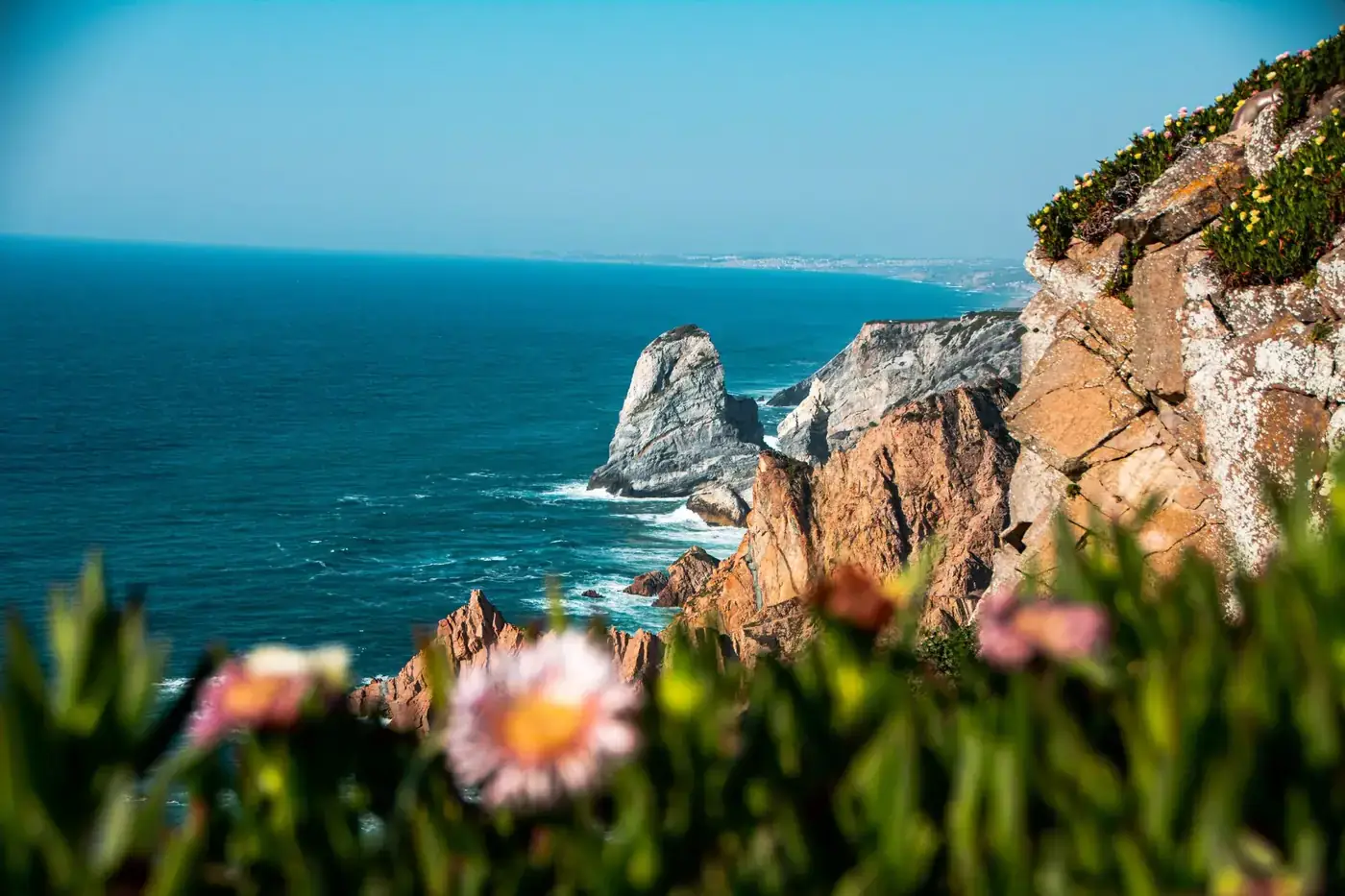 Breathtaking view of cliffs and ocean at Praia das Maçãs in Lisbon, Portugal.