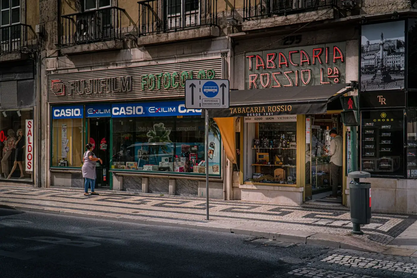Street view of vintage shops in Lissabon, Portugal showcasing Fujifilm and Tabacaria Rossio.
