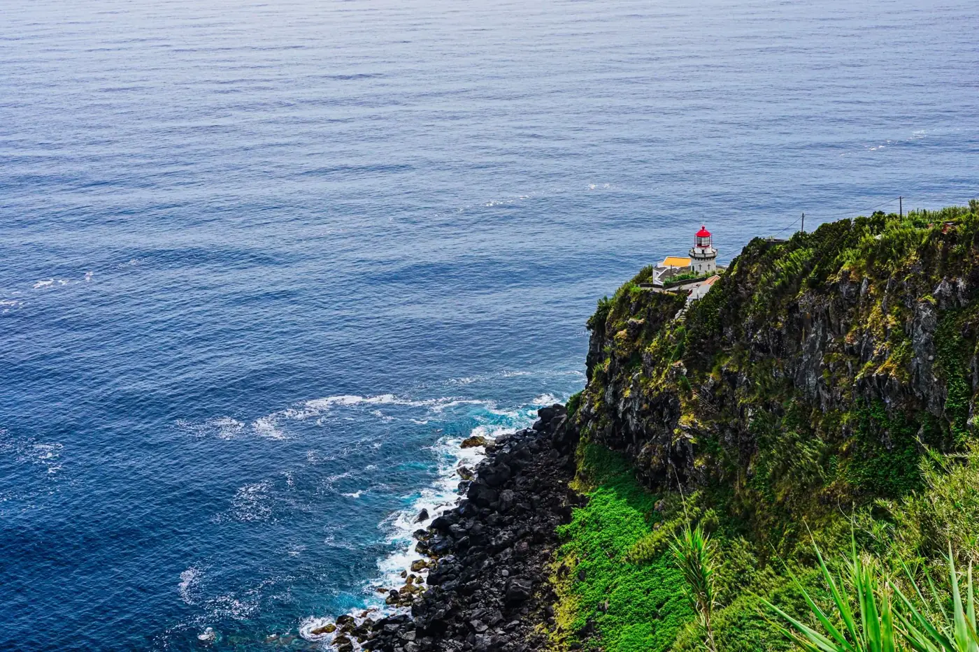 Scenic view of Arnel Lighthouse perched on a cliff in the Azores.