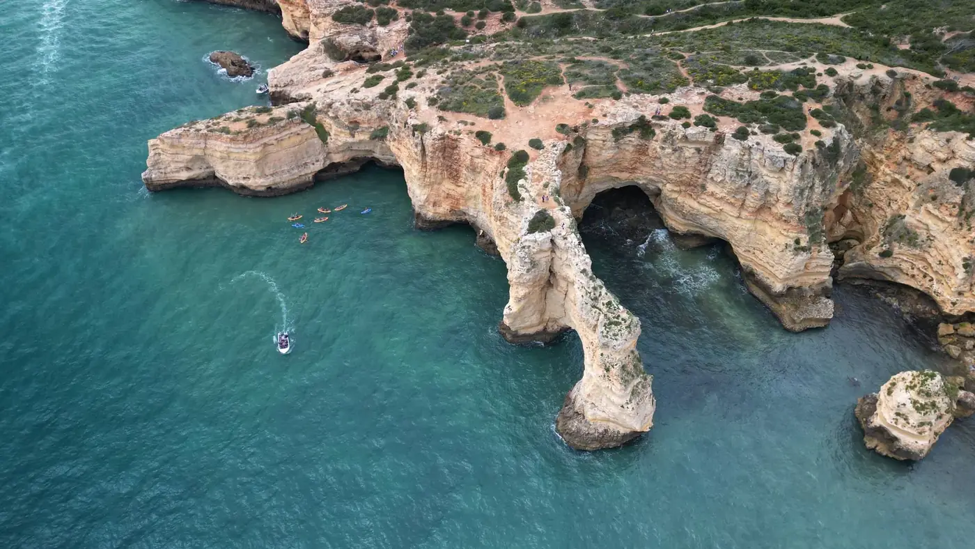 Stunning aerial view of Algarve's rugged cliffs and turquoise coastline in Portugal.