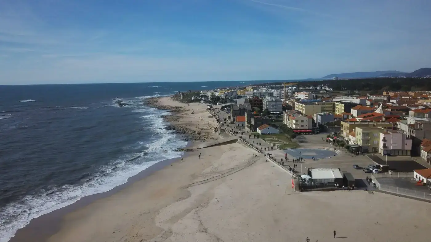 Discover the stunning coastline and vibrant townscape of Apúlia, Portugal from above.