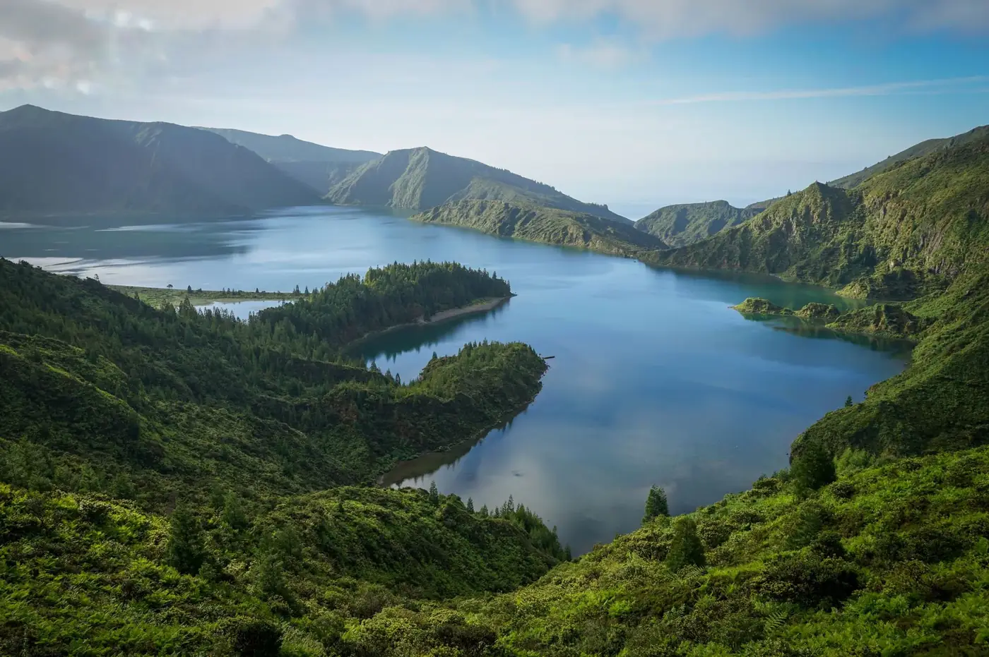 A breathtaking aerial view of Lagoa do Fogo's blue waters surrounded by lush green mountains.