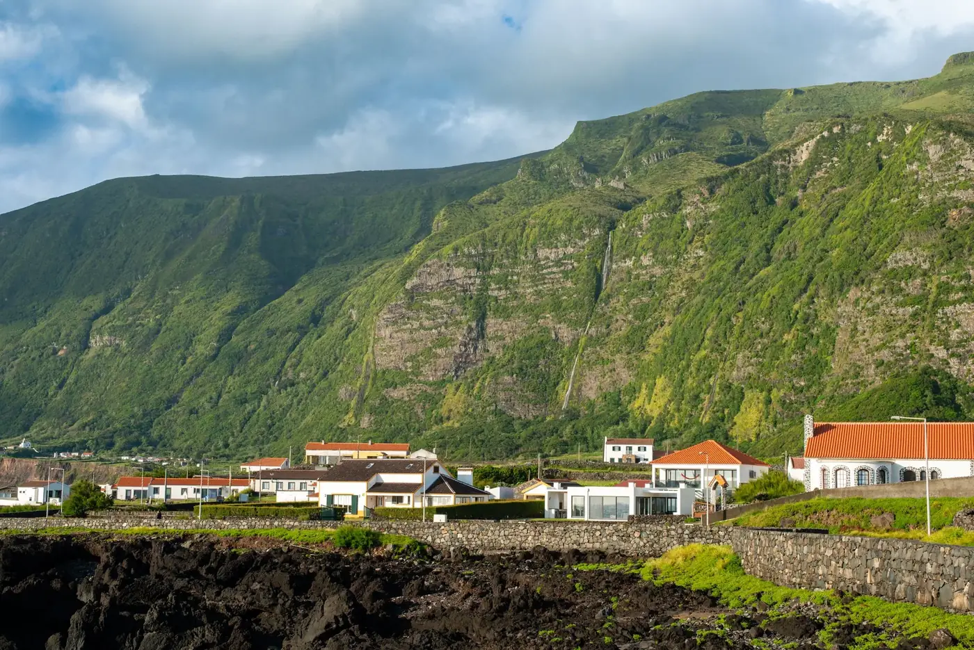 Stunning view of Flores Island with lush green mountains and quaint town in Azores, Portugal.