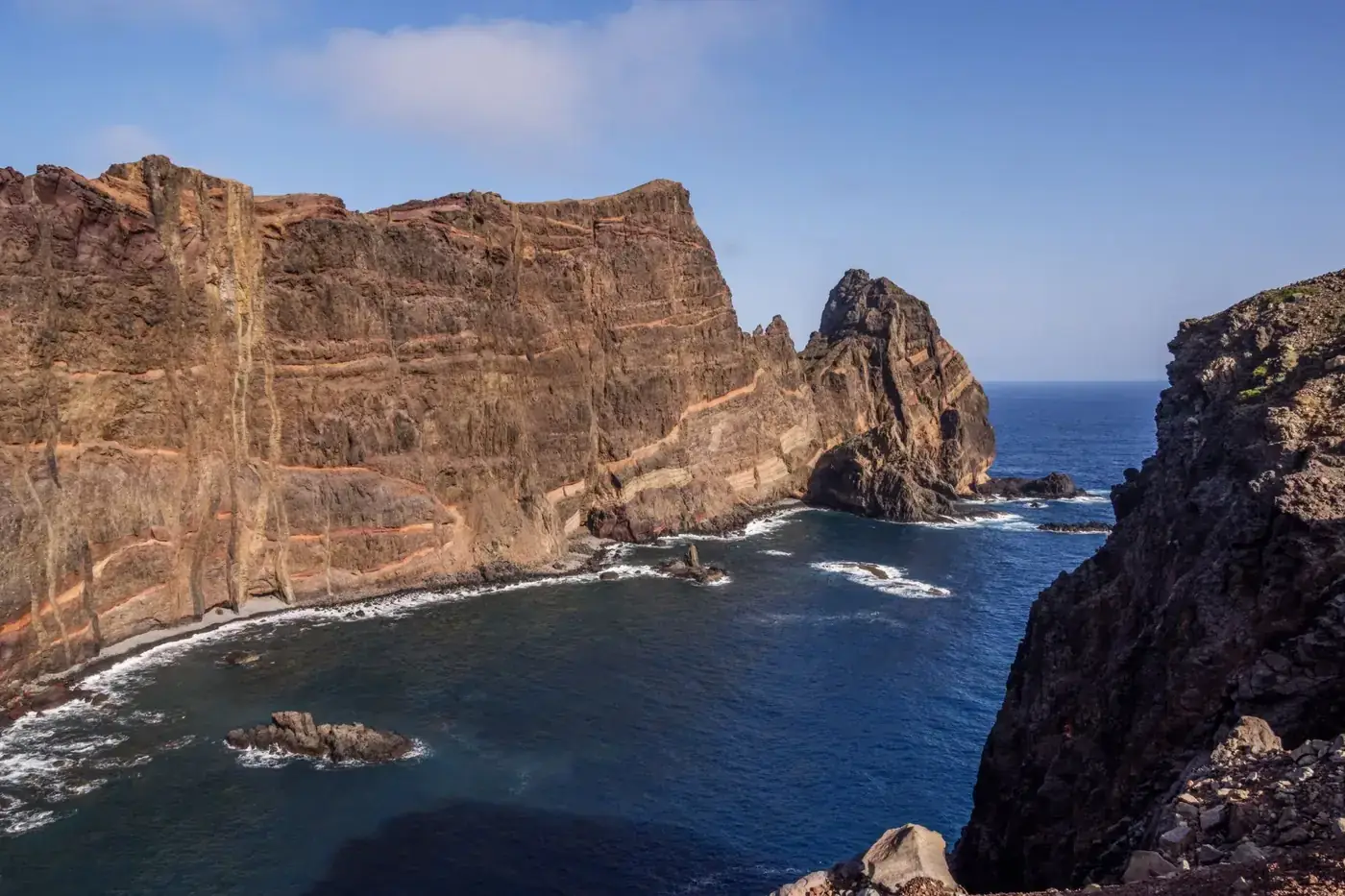 Majestic coastal cliffs overlooking a deep blue ocean, captured in vibrant sunlight.